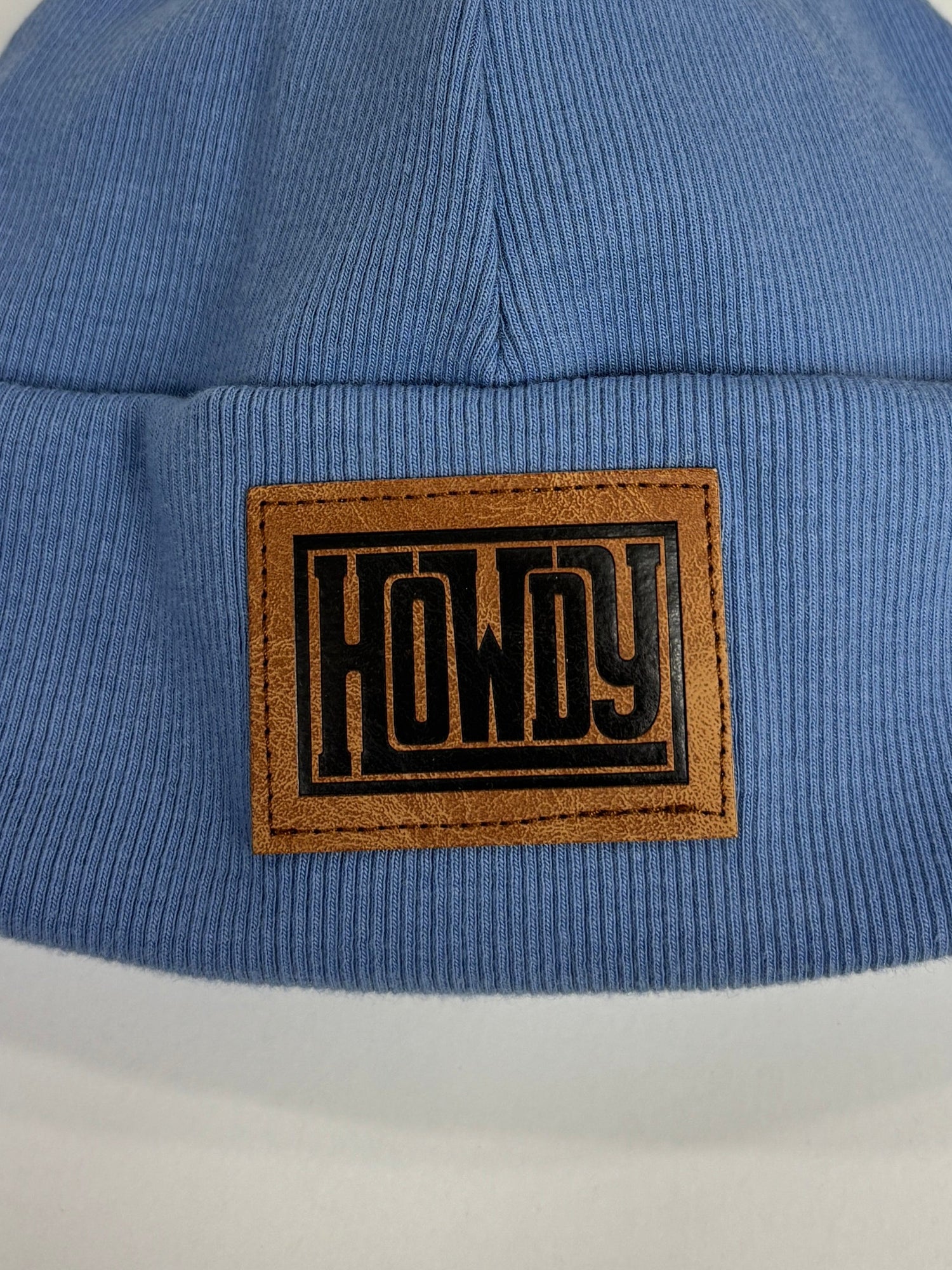 Blue beanie with a brown label on a white background