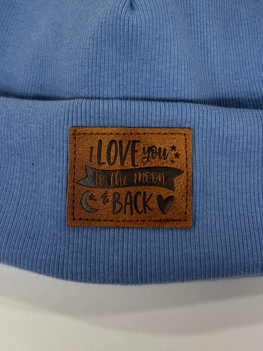 Blue beanie with a pom-pom and a brand label on a white background